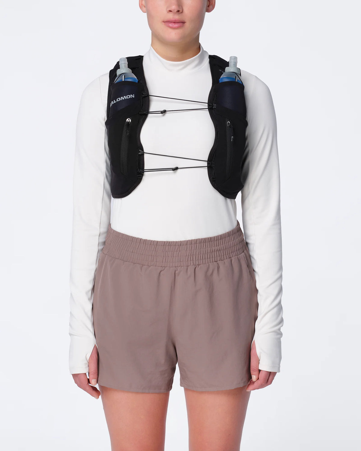 Chaleco de hidratación Salomon ADV Skin 12 para mujer negro puesto por una corredora, vista frontal